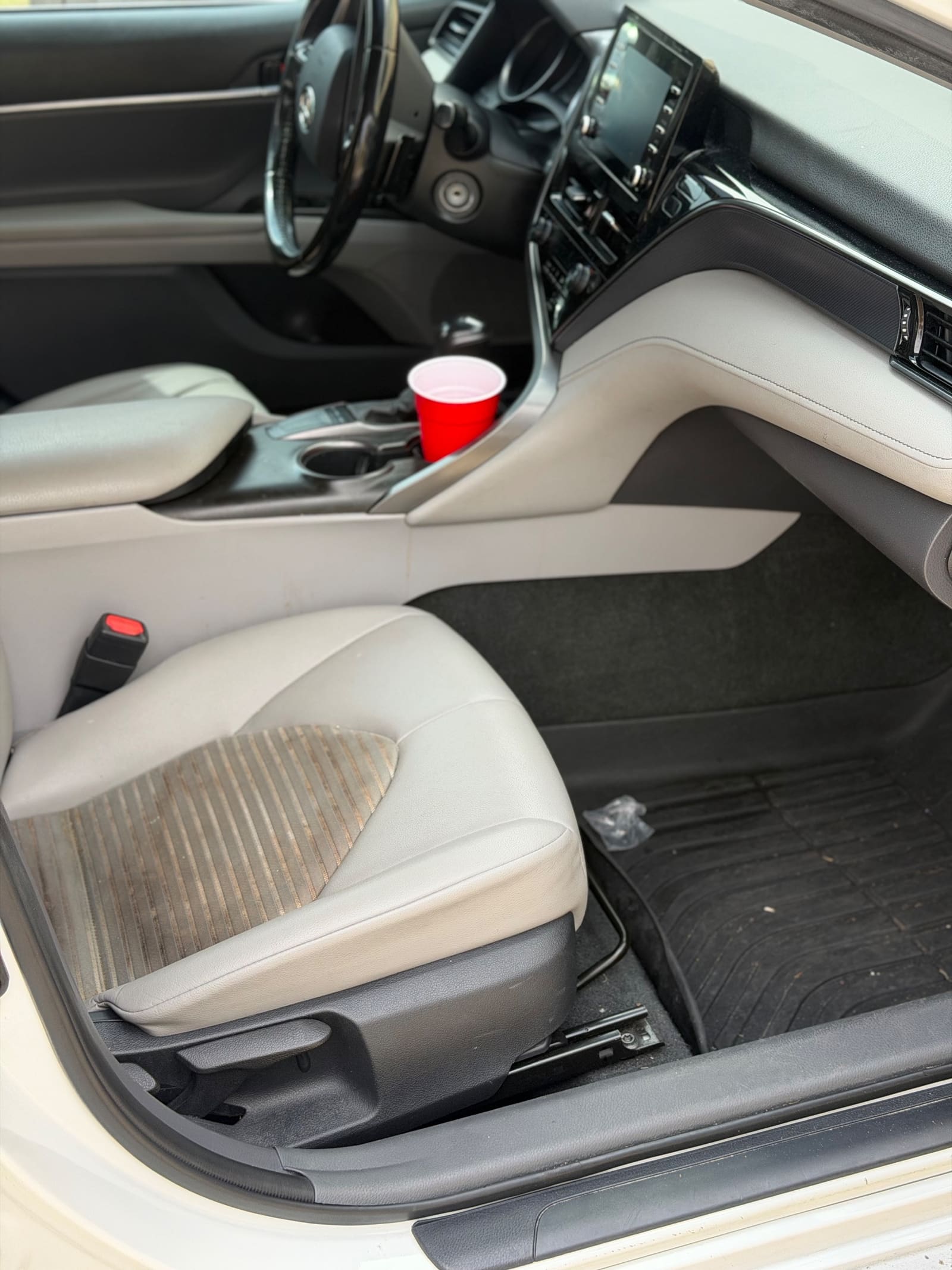 Stained cream seat and dirty console in a Toyota Camry