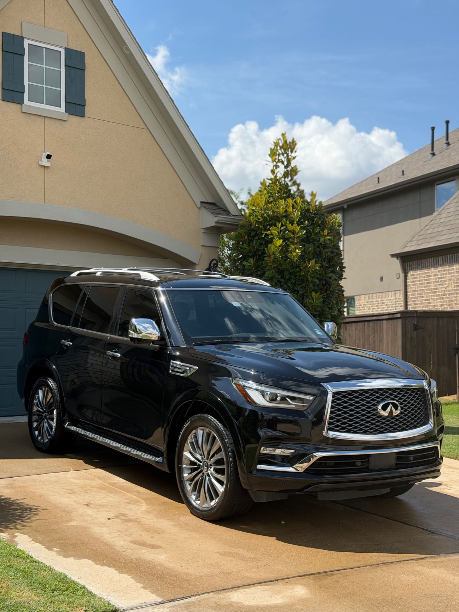 Black Infiniti QX80 on a driveway, paint gleaming after a detail