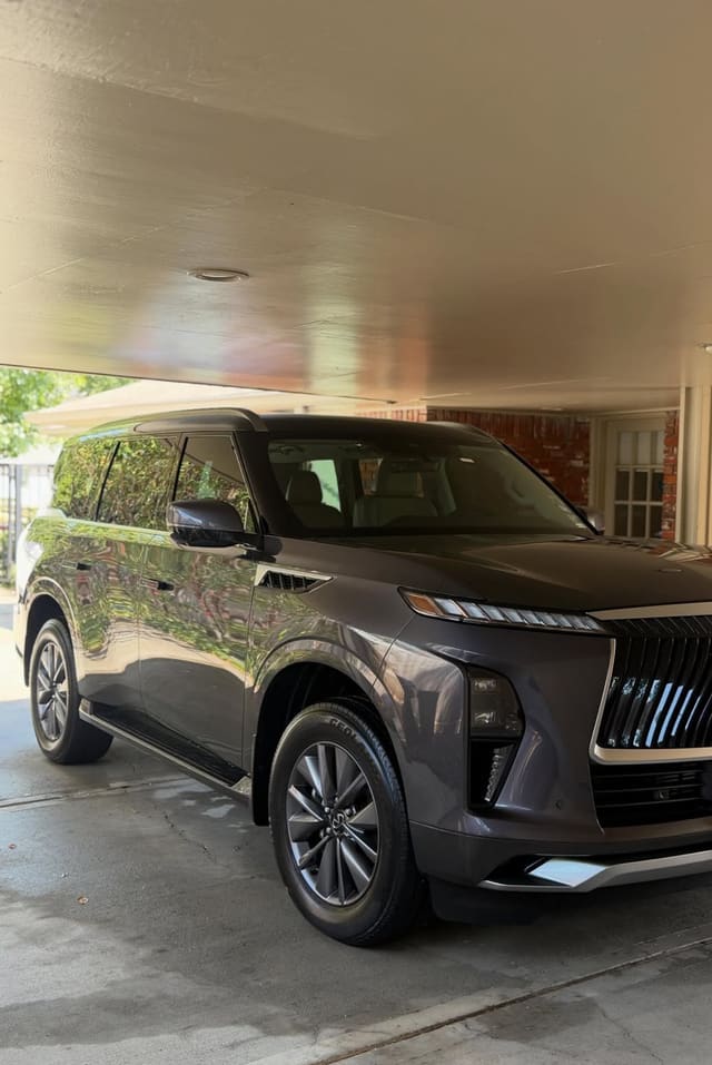 Graphite Infiniti QX80 parked under a porch after a detail